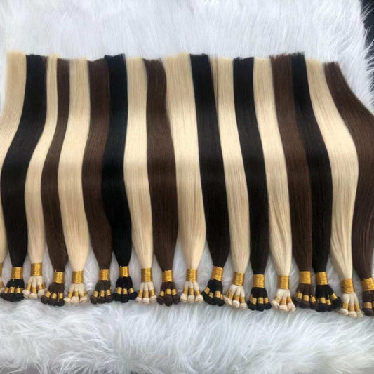 Hand tied weft extensions in various colors, 24-inch length, on a white fur background.